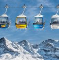 Symbolbild: vier Gondeln von vier Skigebieten vor Eiger, Mönch und Jungfrau-Massiv