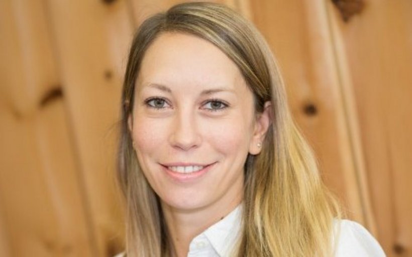 Portrait einer Frau mit langen blonden Haaren, weissem Hemd und heller Haut.