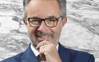 Portrait von Jan E. Brucker, Mann mit grauen Haaren, schwarzer Brille lächelt