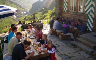Eine SAC Hütte mit Gästen im Aussenbereich