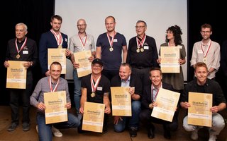 Vertreter/innen der Brennereien des Jahres (obere Reihe v.l.n.r.): Robert Cathomas – Destillaria Daguot, Johnathan Schönberger – Distillerie Studer & Co AG, Thomas Lüscher – DIWISA, Paul Trabes – S. Fassbind AG, Gloria Humbel – Humbel Spezialitätenbrennerei, Daniel Z’graggen – Z’GRAGGEN Distillerie (untere Reihe v.l.n.r.): Toni Schürch – Amstutz Manufaktur, Thomas Heiner – Heiners Destillate, Peter Anderhub – S. Fassbind, Gabrial Galliker-Etter – Etter Söhne AG, Alex Z’graggen – Z’GRAGGEN Distillerie