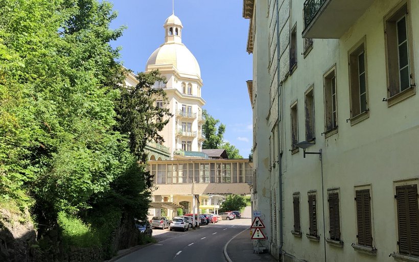 Am ende einer Strasse steht ein grosses Gebäude mit Kuppeldach