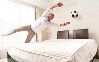 Mann im Hotelzimmer, der einen Ball fängt