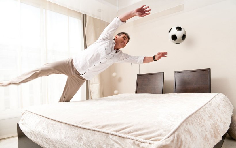 Mann im Hotelzimmer, der einen Ball fängt