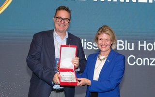 Inge Huijbrechts übergibt den Preis an Markus Conzelmann, General Manager des Hotel Radisson Blu Luzern.