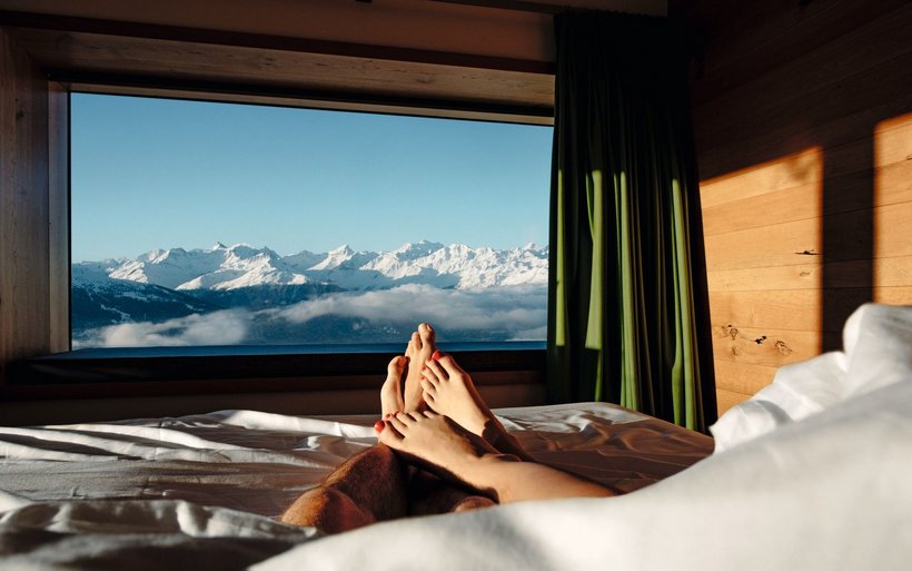 Personen liegen in einem Bett und geniessen Aussicht auf Bergpanorama