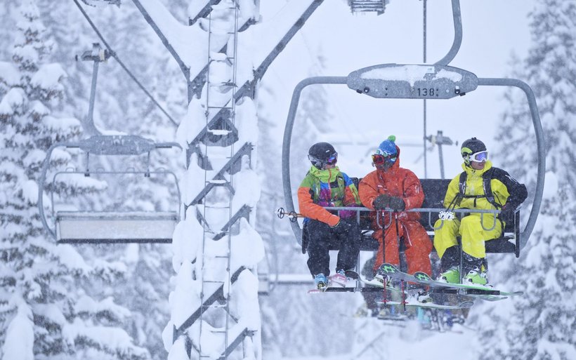 Skifahrende auf einem beschneiten Sessellift
