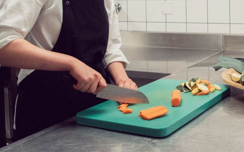 Professioneller Koch schneidet Gemüse