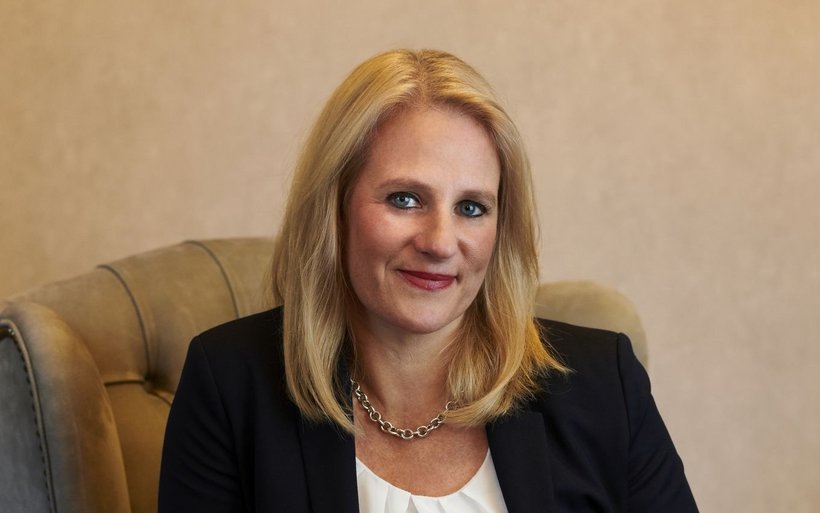 Frau mit blonden Haaren sitzt auf einem Sessel